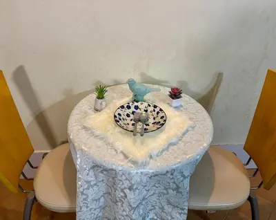 a table with a bird statue on top of it at Ally home 12 23 in Thung Si Kan