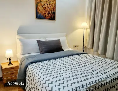 a bedroom with a bed with a black and white comforter at Friend Nest Bangkok in Bangkok