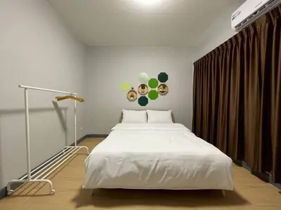 a bedroom with a large white bed in a room at Ananta House in Bang Su