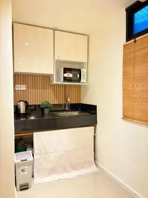 a kitchen with a sink and a microwave at Be Cozy Silom Modern 2BR 1-min to BTS & MRT in Bangkok
