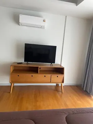 a tv on top of a wooden dresser in a room at Kin Bangkok in Bangkok