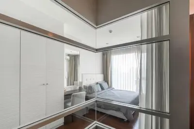 a bedroom with a bed and a glass wall at Luxury Condo with Swimming Pool, Fast Wifi, 711, Big Room, Jacuzzi in Bangkok