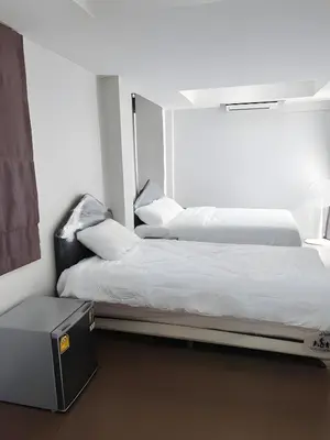 two beds sitting next to each other in a room at XX Mitr Inn MRT Samyot - ตรอกวิสูตร MRT สามยอด in Bangkok