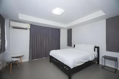 a bedroom with a bed and a table and a chair at XX Mitr Inn MRT Samyot - ตรอกวิสูตร MRT สามยอด in Bangkok