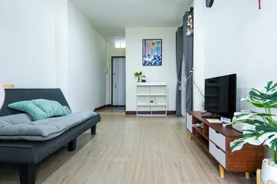 a living room with a couch and a tv at Baan ABC at 112 Phahonyothin 55 in Bang Khen