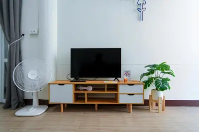 a living room with a tv on a wooden entertainment center at Baan ABC at 112 Phahonyothin 55 in Bang Khen