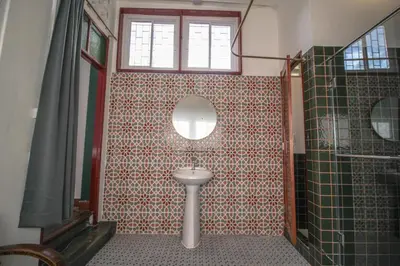 a bathroom with a toilet and a window and a mirror at The Open House Cafe and Hostel in Bangkok
