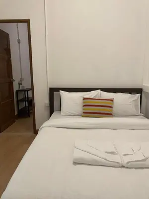 a large white bed with two pillows on it at The Open House Cafe and Hostel in Bangkok