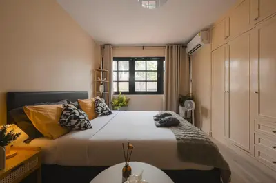 a bedroom with a large bed and a window at 4BR 10PAX 2min 7Eleven & 7min Commons Thonglor in Sathani Khlong Tan