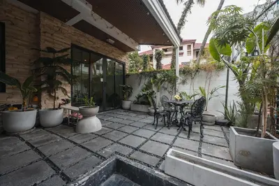 a patio with a table and chairs and plants at 4BR 10PAX 2min 7Eleven & 7min Commons Thonglor in Sathani Khlong Tan