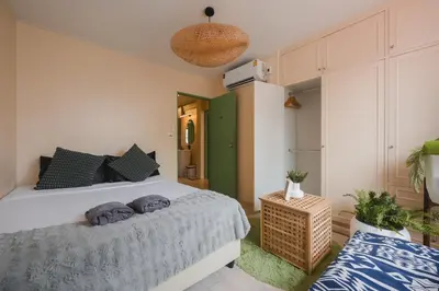 a bedroom with a white bed and a green wall at 4BR 10PAX 2min 7Eleven & 7min Commons Thonglor in Sathani Khlong Tan