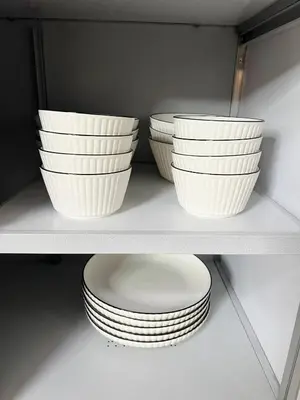 three bowls and plates sitting on a shelf at Everything Within Minutes House in Bangkok