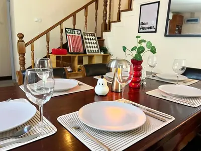 a wooden table with plates and wine glasses on it at Everything Within Minutes House in Bangkok