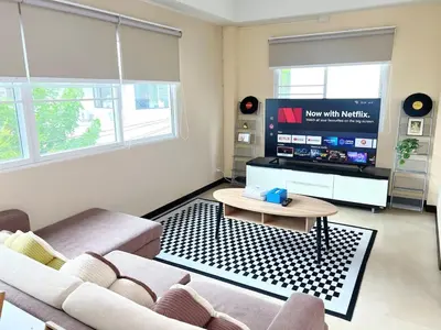 a living room with a couch and a tv at Everything Within Minutes House in Bangkok