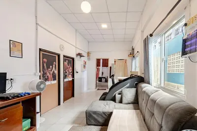 a living room with a couch and a tv at Room 1 Homestay Near BTS Bangwa & Train Muaythai in Bangkok