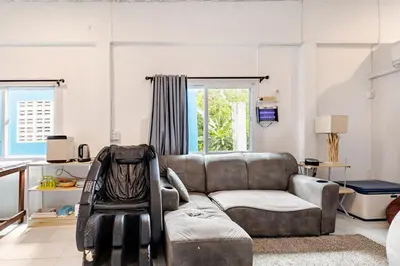 a living room with a couch and a chair at Room 1 Homestay Near BTS Bangwa & Train Muaythai in Bangkok