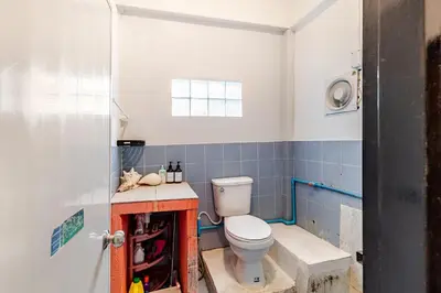 a bathroom with a toilet and a blue tiled wall at Room 1 Homestay Near BTS Bangwa & Train Muaythai in Bangkok