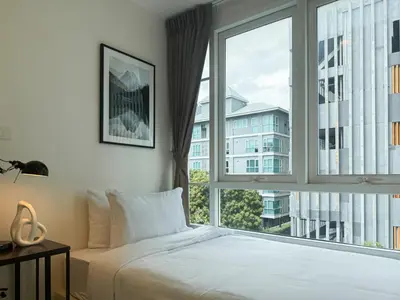 a bedroom with a bed and a large window at Modern Stay Near ICONSIAM l Steps to BTS Krung Thon Buri l Ultra Fast WiFi in Bangkok