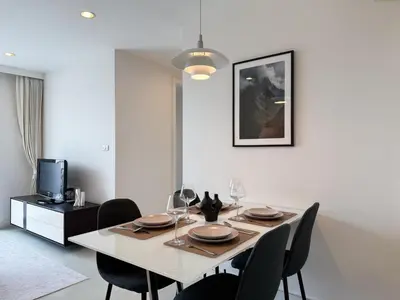 a dining room with a white table and chairs at Modern Stay Near ICONSIAM l Steps to BTS Krung Thon Buri l Ultra Fast WiFi in Bangkok