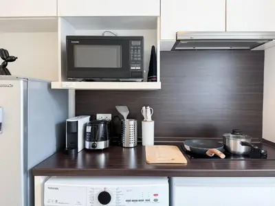 a kitchen with a counter top with a microwave at Modern Stay Near ICONSIAM l Steps to BTS Krung Thon Buri l Ultra Fast WiFi in Bangkok
