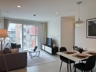 a living room with a couch and a table at Modern Stay Near ICONSIAM l Steps to BTS Krung Thon Buri l Ultra Fast WiFi in Bangkok