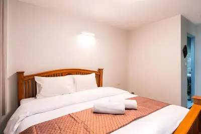 a bedroom with a large bed with white pillows at XX GO INN Khaosan โก อินน์ ตรอกข้าวสาร in Bang Bua Thong Railway Station