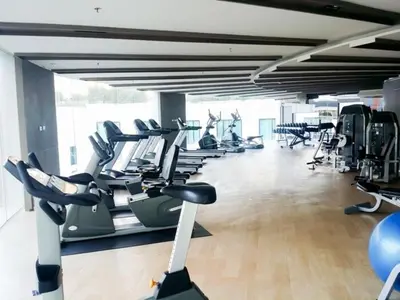 a gym with rows of treadmills and exercise bikes at Cozy Private Home I Steps to BTS & MRT Sukhumvit Minimum 14 nights in Bangkok