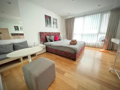 a bedroom with a bed and a table and a couch at Cozy Private Home I Steps to BTS & MRT Sukhumvit Minimum 14 nights in Bangkok