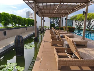 a row of tables and chairs next to a body of water at Condo 1B1BR Sukhumvit 103 BTS Udomsuk in Phra Khanong