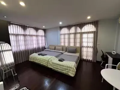 a bedroom with a large bed and two windows at 4BR 12PAX 7min walk to Samitivej Sukhumvit Hospital in Khlong Toei