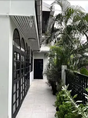 a hallway leading to a building with a black door at 4BR 12PAX 7min walk to Samitivej Sukhumvit Hospital in Khlong Toei