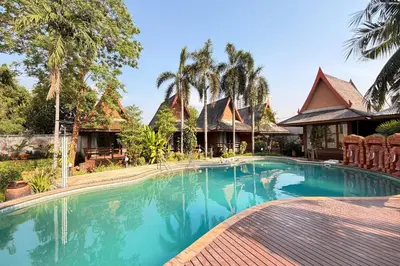 a swimming pool in front of a house at The Grand Imperial in Ban Song Hong