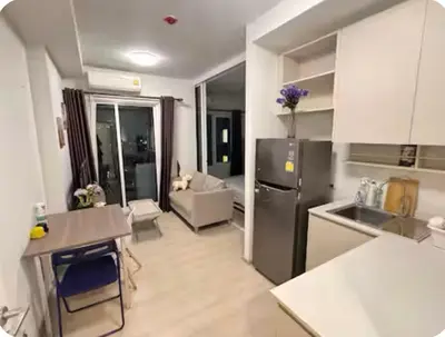 a kitchen with a stainless steel refrigerator and a living room at Chapter One Eco Ratchada-HuaiKhwang in Bangkok