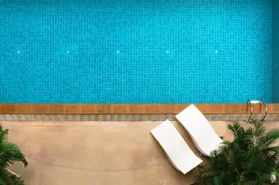 two white chairs sitting next to a swimming pool at KingBed|BTS&Park»5min|ParkView|Gym|Washer|FastWiFi in Khlong Toei