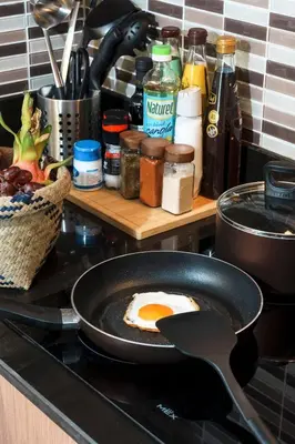 a frying pan with an egg in it on a stove at KingBed|BTS&Park»5min|ParkView|Gym|Washer|FastWiFi in Khlong Toei
