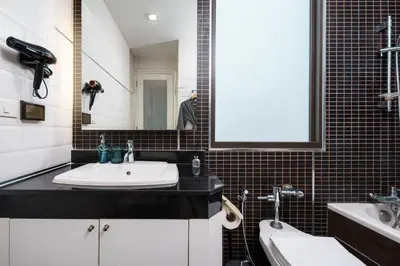 a bathroom with a sink and a mirror at Quiet Asoke/Nana BTS Retreat w/ Skyline & Gym/Park in Khlong Toei