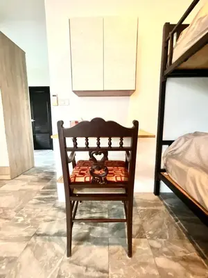 a wooden chair in a room with a bed at Impact Arena & DMK - 4BR 12pax Home 55