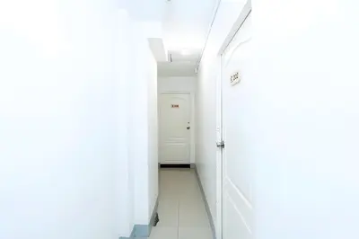 a hallway with white walls and a white door at XX Oh My Nap BTS NANA in Makkasan