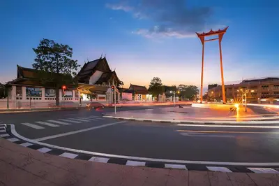 an empty city street at night with a crosswalk at xxGO INN The Giant Swing - โกอินน เสาชิงช้า in Bangkok