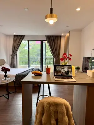 a room with a desk with a laptop on it at Common Living Ekkamai in Bangkok
