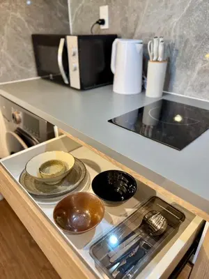 a kitchen counter top with a stove top oven at Common Living Ekkamai in Bangkok