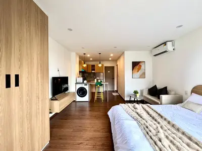 a bedroom with a bed and a living room at Common Living Ekkamai in Bangkok