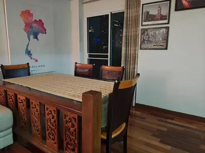 a dining room with a table and chairs and a window at At Sathon apartment in Bangkok