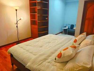 a bedroom with a large bed with pillows on it at At Sathon apartment in Bangkok