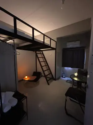 a room with a bunk bed with a ladder at Munchies Bed & Breakfast in Bangkok