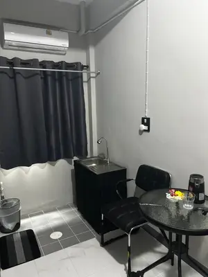 a dining room with a table and a sink at Munchies Bed & Breakfast in Bangkok