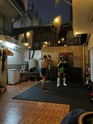 a man standing next to another man in a boxing ring at Munchies Bed & Breakfast in Bangkok