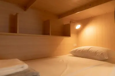a bed with a white pillow in a room at Monument Stay in Bangkok
