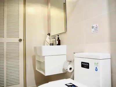 a bathroom with a toilet and a sink and a mirror at Cozy home with car parking near MRT Lat Phrao & Phawana in Bangkok