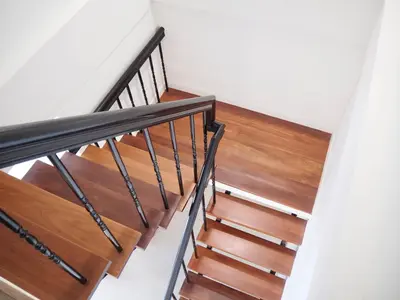 a staircase in a house with wooden floors at Cozy home with car parking near MRT Lat Phrao & Phawana in Bangkok